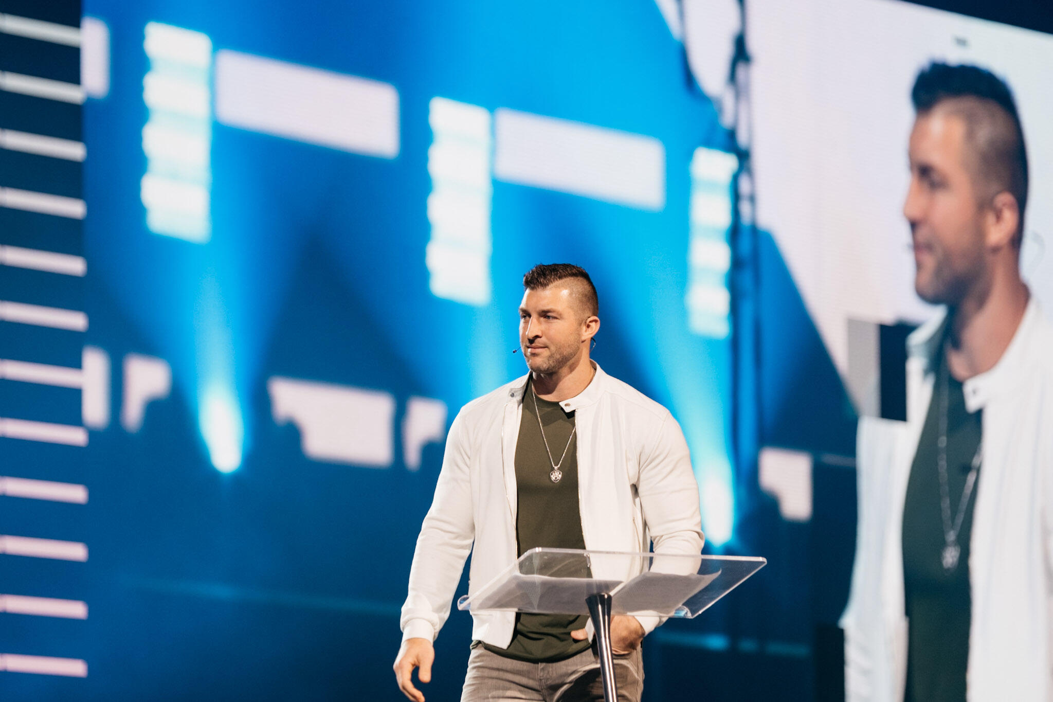 Tim Tebow speaking on stage at a conference